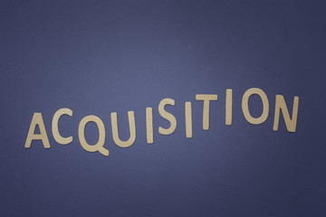 Acquisition written with wooden letters on a blue background
