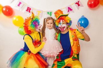 Obraz na płótnie Canvas clown boy and clown girl on birthday girl. Party for children. Clowns amuse the child