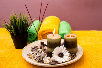 Burning candles with towels lying on the table in the massage parlor