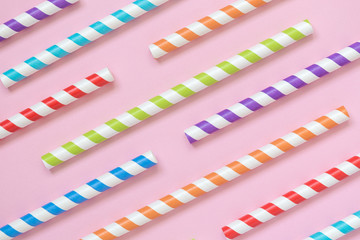 Multicolored drinking straws texture against rose background minimalistic concept