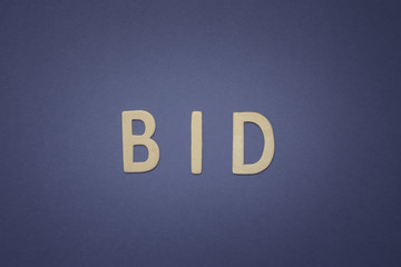 Bid written with wooden letters on a blue background