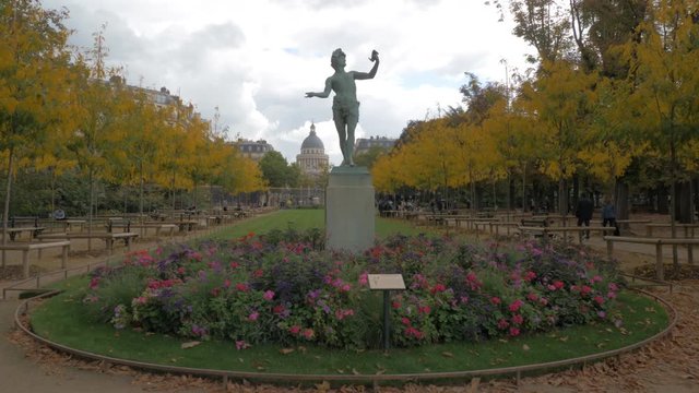 PARIS, FRANCE - SEPTEMBER 29, 2017: Coming up to the statue of The Greek Actor in Luxembourg Garden. Autumn view with walking people and Pantheon in background