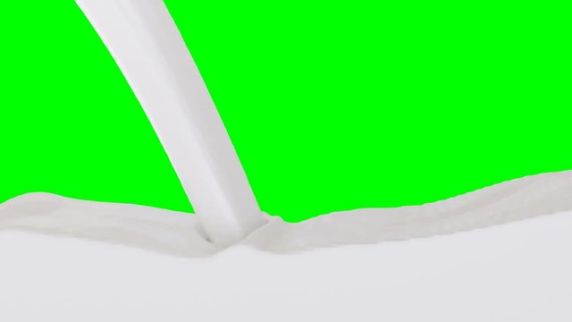 Animated white paint, condensed milk or heavy cream pouring and splashing rapidly filling up whole container against green background. One inflow source.