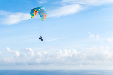 Flying a tandem paraglider over the sea with views of the horizon