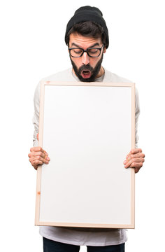 Surprised Hipster man holding an empty placard on white background