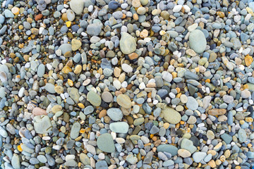 Smooth round pebbles sea texture background. Pebble on a beach. Gravel stone seashore.