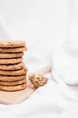 Close up of a sweet homemade cookies on a wooden board on a bed sheet