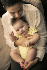 Young mother with her baby girl at home.