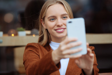 Portrait of delighted blonde that making selfie