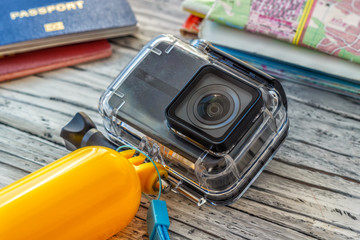 Conceptual photography of tourism, action camera, planning a trip with a card, passport, mobile phone and camera action.