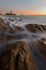 wave at the sea on the rock with sunset sky