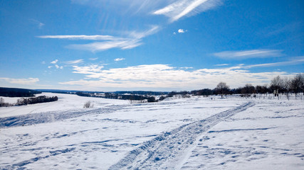 Fototapeta na wymiar Winter landscape of nature. The river Oka froze and covered with snow. In nature in winter Russia. Clear blue sky with clouds.