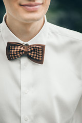 man in white shirt and brown bow tie