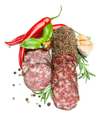 Dried organic salami sausage covered with pepper on white background