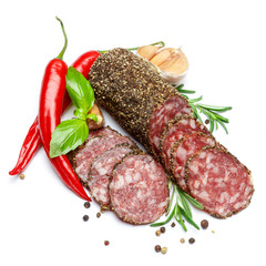 Dried organic salami sausage covered with pepper on white background