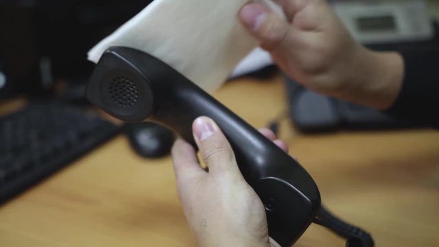 office worker wipes the phone