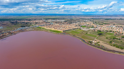 Fototapeta na wymiar Aerial view on the pink salt lake and Aigues-Mortes - medieval fortified town in South France