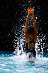 Woman at the swimming pool splattering water