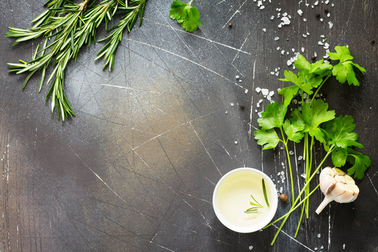 Food background. Parsley and rosemary on a dark stone table. Copy space, top view flat lay background.
