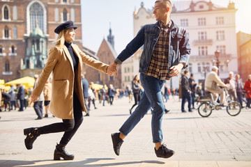 Lovely couple run on the street and smile