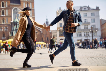 Lovely couple run on the street and smile