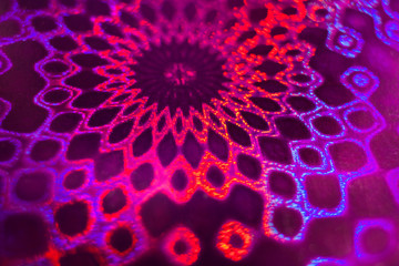 Close-up radial pink-violet holographic pattern like mandala or lace.
