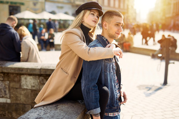 Lovely couple stand on city landscape and hug each other with sun on background