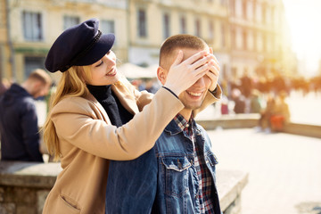 Lovely couple stand on city landscape and hug each other with sun on background