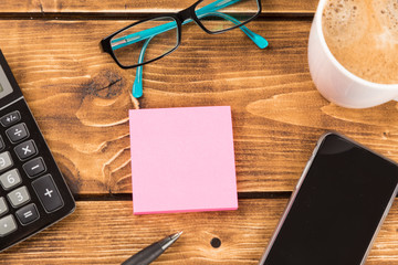 desk with paper, pen,  smartphone, glasses, coffee and calculator