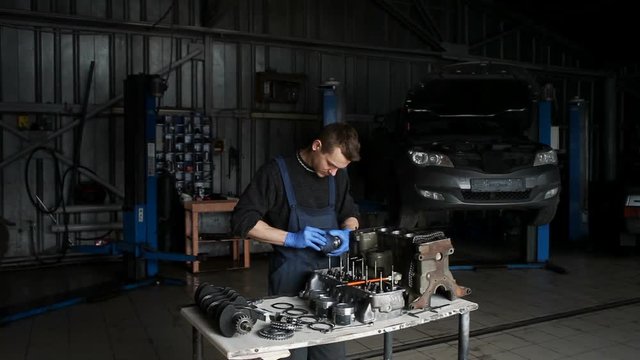 Male mechanic collects a rebuilt motor for the car