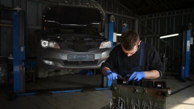 Male mechanic collects a rebuilt motor for the car