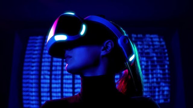 Profile portrait of young woman in VR headset looks around and wonders how amazing. Virtual reality interactive helmet on brarcode matrix background