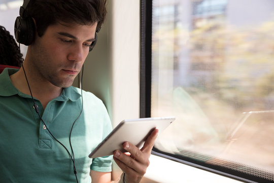 Commuter watching video on tablet on poblic transport