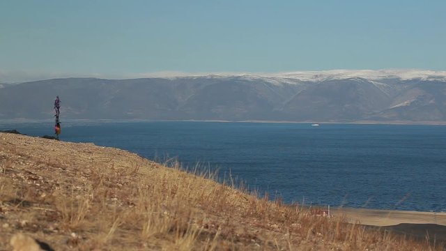View of the Baikal lake coast. Pure water, waves. Clear day. There are mountains on the other side of the lake. Perfect calm blue background. Olkhon Island. Looped