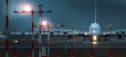 working airport beacons with starting airplane in the evening