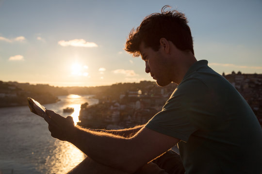 Man looking at touristic map at sunset