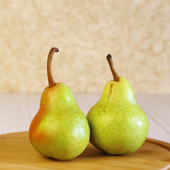Food. Vegetarian fruit dessert. Healthy eating. Fresh fruits. Two ripe pears on a table in the sunlight.