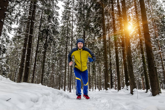 man Jogging on the trail in the  winter forest