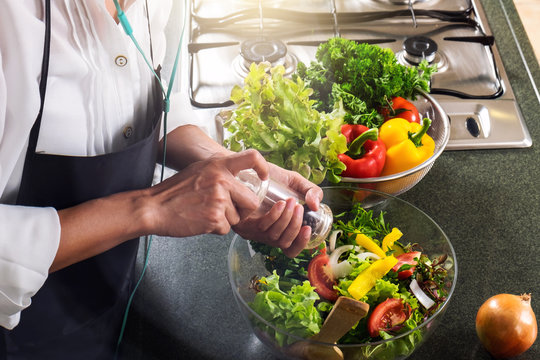 Young happiness Woman Cooking vegetables salad in the kitchen, Healthy food concept