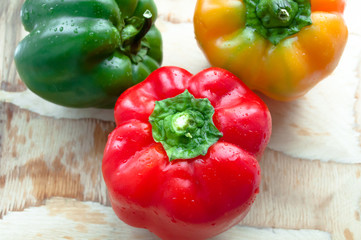 Assorted colorful varieties of bulgarian peppers sitting on old wooden table