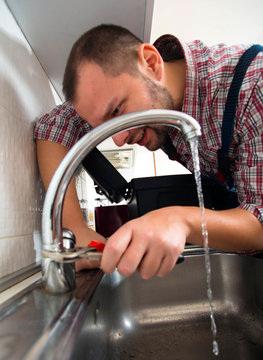 Repairman repair faucet with wrench