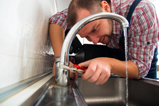 Repairman repair faucet with wrench