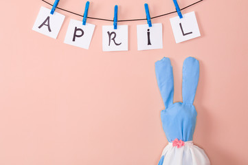 inscription April and rabbit on colored background