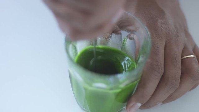 top view of glass with matcha tee preparing using electric mixer