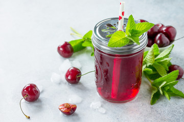 Diet vitamin drink or the concept of vegetarian food. Homemade refreshing drink with cherry and mint, on a concrete or stone table. Copy space.