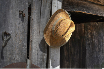 image of straw hat hanging on old shed