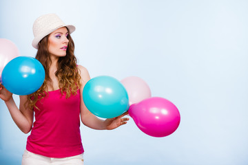 Naklejka premium Woman playing with many colorful balloons