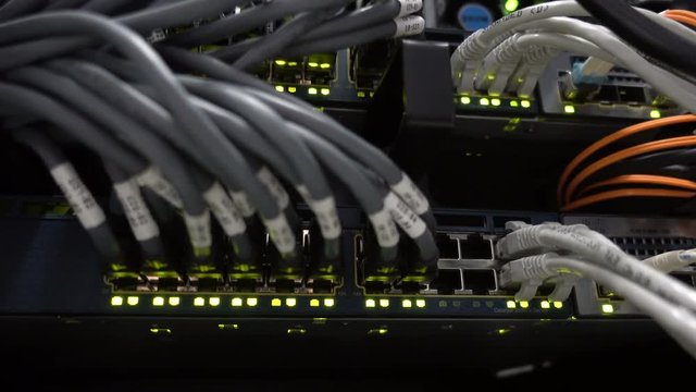 Modern network switch with cables. Flashing server lamp, switch, router. Severs computer in a rack at the large data center. 
