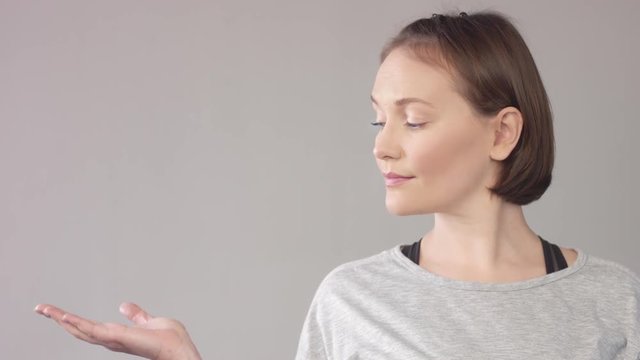 woman looking at camera and then pull up her hand with nothing on it. Promotion video