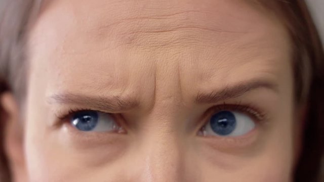 closeup of woman s blue eyes and forehead showing different emotions. Andry, wondering, wrinkles on forehead